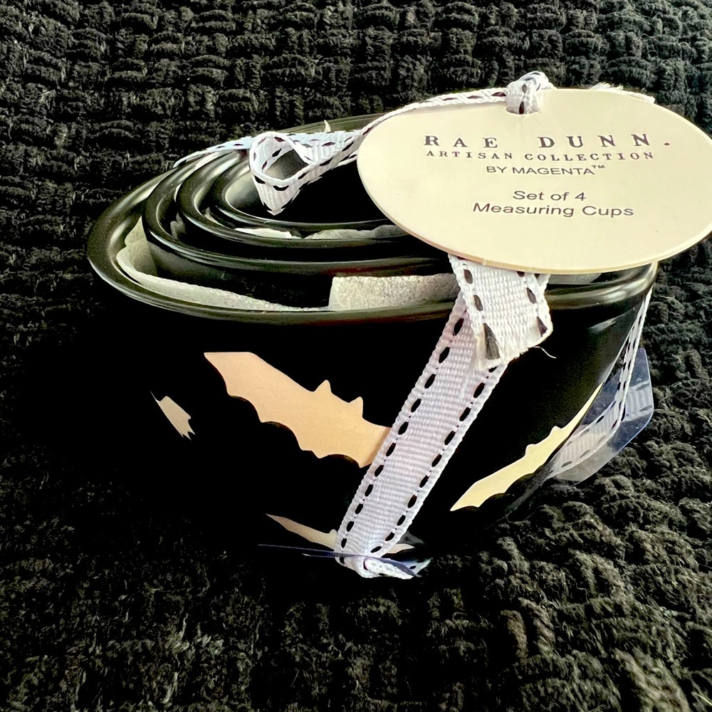 Rae Dunn black measuring cups with white bats.